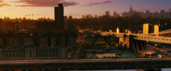 Movie still from “The Debt” (2010), directed by John Madden – A view of a city at sunset with a bridge in the background; Extreme Wide shot, High angle