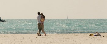 Movie still from “The Debt” (2010), directed by John Madden – A man and a woman walking on the beach; Wide shot, Over the shoulder angle
