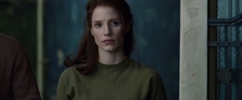 Movie still from “The Debt” (2010), directed by John Madden – A woman in a green sweater is looking at the camera; Close Up shot, Over the shoulder angle