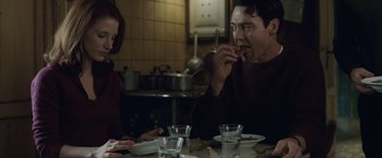 Movie still from “The Debt” (2010), directed by John Madden – A man and a woman sitting at a dinner table; Medium shot, Over the shoulder angle