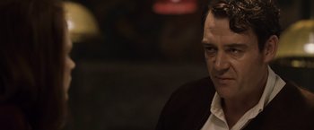 Movie still from “The Debt” (2010), directed by John Madden – A person wearing a white shirt; Close Up shot, Low angle