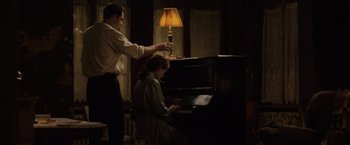 Movie still from “The Debt” (2010), directed by John Madden – A man and a woman are playing a piano together; Medium shot, High angle