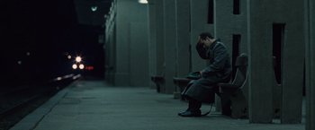 Movie still from “The Debt” (2010), directed by John Madden – A man sitting on a bench with his head in his hands; Wide shot, Over the shoulder angle