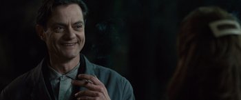 Movie still from “The Debt” (2010), directed by John Madden – A person wearing a suit and tie; Close Up shot, Over the shoulder angle