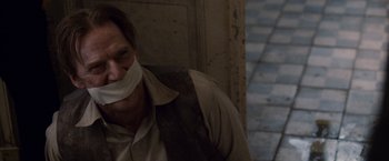 Movie still from “The Debt” (2010), directed by John Madden – A man with his mouth taped shut; Close Up shot, Over the shoulder angle