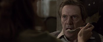 Movie still from “The Debt” (2010), directed by John Madden – An older man with a tooth brush in his mouth; Close Up shot, Low angle