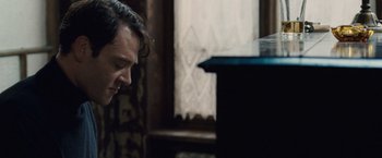 Movie still from “The Debt” (2010), directed by John Madden – A person playing a musical instrument; Close Up shot, High angle