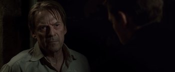 Movie still from “The Debt” (2010), directed by John Madden – A man in a white shirt is looking at another man; Close Up shot, Over the shoulder angle