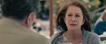 Movie still from “The Debt” (2010), directed by John Madden – An older woman is sitting in front of a man; Close Up shot, Over the shoulder angle