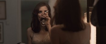 Movie still from “The Debt” (2010), directed by John Madden – A woman is drinking a glass of wine in front of a mirror; Close Up shot, Over the shoulder angle