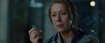 Movie still from “The Debt” (2010), directed by John Madden – An older woman is holding a cigarette in her hand; Close Up shot, Low angle