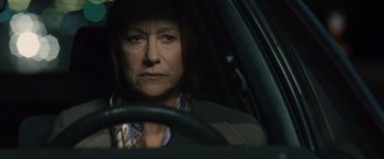 Movie still from “The Debt” (2010), directed by John Madden – A woman sitting in the driver's seat of a car at night; Close Up shot, Over the shoulder angle
