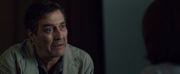 Movie still from “The Debt” (2010), directed by John Madden – An older man looking at the camera with a surprised look on his face; Close Up shot, Over the shoulder angle