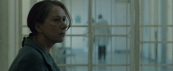 Movie still from “The Debt” (2010), directed by John Madden – A woman standing next to a window in a room; Close Up shot, Low angle