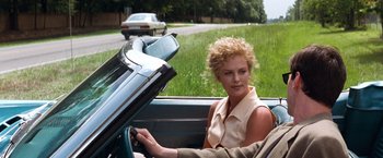 Movie still from “The Devil's Advocate” (1997), directed by Taylor Hackford – A woman sitting in the back of a car; Medium shot, Over the shoulder angle