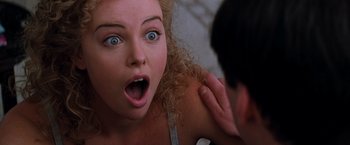 Movie still from “The Devil's Advocate” (1997), directed by Taylor Hackford – A young woman with a surprised look on her face; Close Up shot, Over the shoulder angle