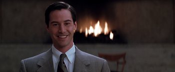 Movie still from “The Devil's Advocate” (1997), directed by Taylor Hackford – A man wearing a suit and tie in front of a fireplace; Close Up shot, Over the shoulder angle