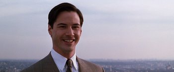 Movie still from “The Devil's Advocate” (1997), directed by Taylor Hackford – A man in a suit and tie smiling; Close Up shot, Low angle