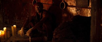 Movie still from “The Devil's Advocate” (1997), directed by Taylor Hackford – A man sitting on the ground in a dark room; Medium shot, Low angle