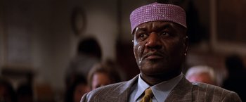 Movie still from “The Devil's Advocate” (1997), directed by Taylor Hackford – A person wearing a suit and a hat; Close Up shot, Low angle