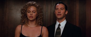 Movie still from “The Devil's Advocate” (1997), directed by Taylor Hackford – A man and a woman standing next to each other; Close Up shot, Low angle