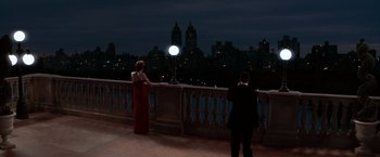 Movie still from “The Devil's Advocate” (1997), directed by Taylor Hackford – A man and a woman standing on a balcony at night; Wide shot, High angle