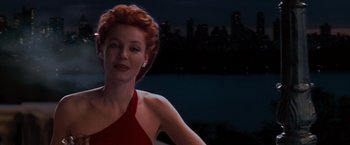 Movie still from “The Devil's Advocate” (1997), directed by Taylor Hackford – A woman in a red dress standing in front of a body of water at night; Medium shot, Low angle