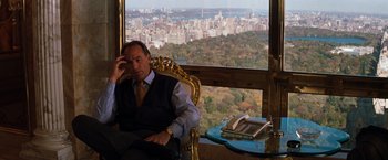 Movie still from “The Devil's Advocate” (1997), directed by Taylor Hackford – A man sitting in a chair in front of a large window; Medium shot, High angle