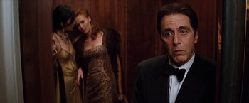 Movie still from “The Devil's Advocate” (1997), directed by Taylor Hackford – A man and a woman standing in front of another man in a suit; Medium shot, Low angle