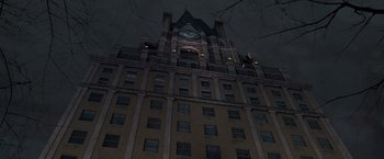 Movie still from “The Devil's Advocate” (1997), directed by Taylor Hackford – A large building with a clock on the top of it; Extreme Wide shot, Low angle