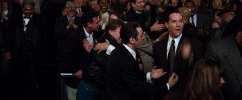 Movie still from “The Devil's Advocate” (1997), directed by Taylor Hackford – A group of men in suits and ties clapping; Wide shot, High angle