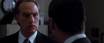 Movie still from “The Devil's Advocate” (1997), directed by Taylor Hackford – A man in a suit and tie looking at another man in a suit and tie; Close Up shot, Over the shoulder angle