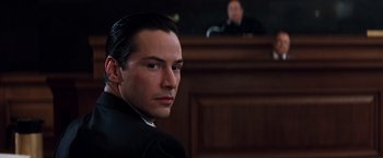 Movie still from “The Devil's Advocate” (1997), directed by Taylor Hackford – A man sitting in front of a judge in a courtroom; Close Up shot, Low angle
