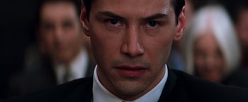 Movie still from “The Devil's Advocate” (1997), directed by Taylor Hackford – A person wearing a suit and tie; Close Up shot, Over the shoulder angle