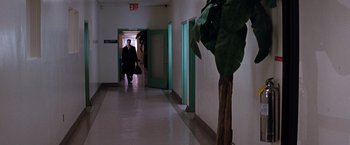 Movie still from “The Devil's Advocate” (1997), directed by Taylor Hackford – A man walking down a hallway in a building; Wide shot, Over the shoulder angle
