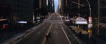 Movie still from “The Devil's Advocate” (1997), directed by Taylor Hackford – An empty city street with a person riding a bike on the sidewalk; Extreme Wide shot, High angle