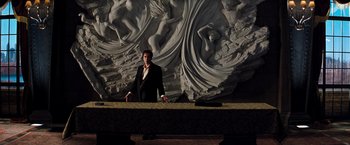 Movie still from “The Devil's Advocate” (1997), directed by Taylor Hackford – A man standing in front of a wall with statues; Wide shot, Low angle
