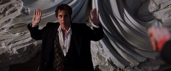 Movie still from “The Devil's Advocate” (1997), directed by Taylor Hackford – A man in a suit and tie holding up his hand; Medium shot, Low angle
