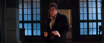 Movie still from “The Devil's Advocate” (1997), directed by Taylor Hackford – A man wearing a suit and tie holding a cell phone; Medium shot, Low angle