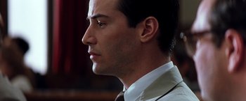 Movie still from “The Devil's Advocate” (1997), directed by Taylor Hackford – A person wearing a suit and tie; Close Up shot, Over the shoulder angle