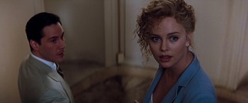 Movie still from “The Devil's Advocate” (1997), directed by Taylor Hackford – A woman with curly blonde hair standing in a bathroom; Close Up shot, Over the shoulder angle