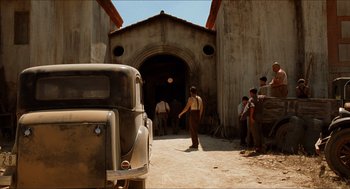 Movie still from “The Devil's Backbone” (2001), directed by Guillermo del Toro – A group of people standing around a building; Extreme Wide shot, Low angle