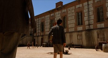 Movie still from “The Devil's Backbone” (2001), directed by Guillermo del Toro – A man standing in front of an old building; Extreme Wide shot, Low angle