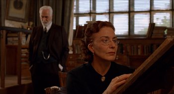 Movie still from “The Devil's Backbone” (2001), directed by Guillermo del Toro – An older woman wearing glasses and an older man wearing a suit; Medium shot, Low angle