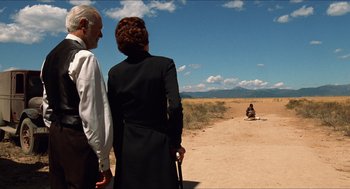 Movie still from “The Devil's Backbone” (2001), directed by Guillermo del Toro – A man and a woman standing on a dirt road; Extreme Wide shot, Over the shoulder angle