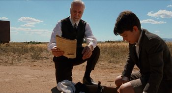 Movie still from “The Devil's Backbone” (2001), directed by Guillermo del Toro – An older man kneeling down next to a young boy; Medium shot, Low angle
