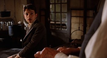 Movie still from “The Devil's Backbone” (2001), directed by Guillermo del Toro – A young boy sitting in front of an older man; Medium shot, Over the shoulder angle