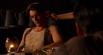 Movie still from “The Devil's Backbone” (2001), directed by Guillermo del Toro – A man sitting at a table with a plate of food in front of him; Medium shot, Over the shoulder angle