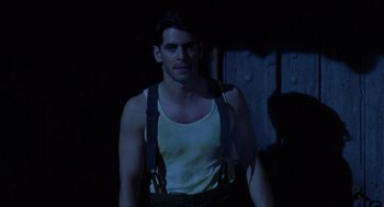 Movie still from “The Devil's Backbone” (2001), directed by Guillermo del Toro – A man in a white tank top and black suspenders; Medium shot, Low angle