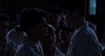 Movie still from “The Devil's Backbone” (2001), directed by Guillermo del Toro – A group of young men standing next to each other in the dark; Close Up shot, Over the shoulder angle